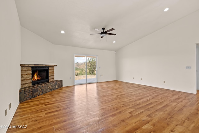 unfurnished living room with ceiling fan, light hardwood / wood-style flooring, lofted ceiling, and a fireplace