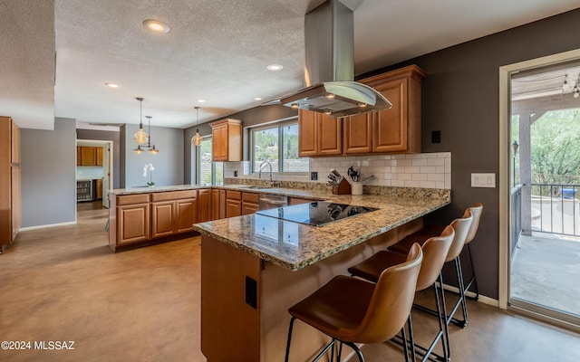 kitchen with a kitchen bar, hanging light fixtures, kitchen peninsula, island range hood, and black electric cooktop