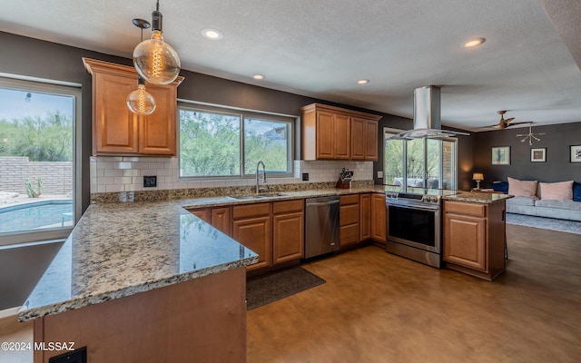 kitchen with kitchen peninsula, sink, hanging light fixtures, stainless steel appliances, and island range hood