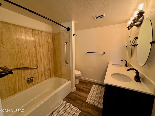 full bathroom with tub / shower combination, hardwood / wood-style floors, a textured ceiling, toilet, and vanity