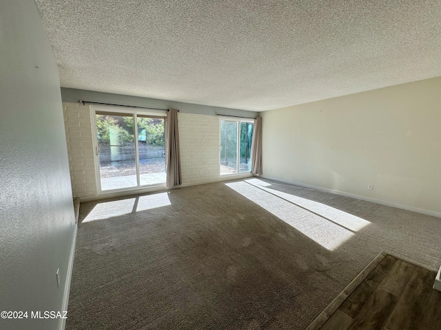 carpeted empty room featuring a textured ceiling