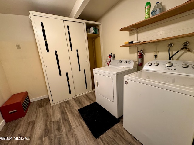 clothes washing area with dark wood-type flooring and washing machine and clothes dryer