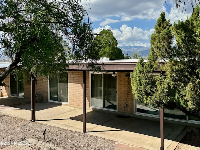 rear view of property with a mountain view and a patio area