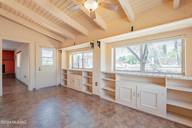 interior space with vaulted ceiling with beams, ceiling fan, built in desk, and wooden ceiling