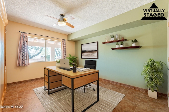 office with a textured ceiling, baseboards, a ceiling fan, and tile patterned floors