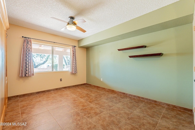 empty room featuring ceiling fan, a textured ceiling, and baseboards