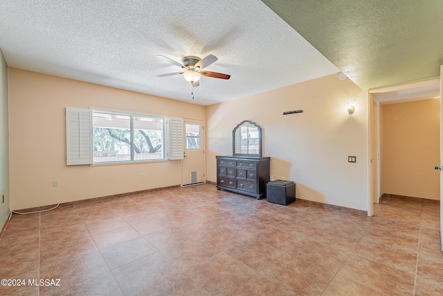 empty room with a textured ceiling, plenty of natural light, and a ceiling fan