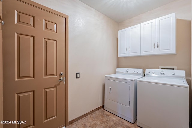 laundry area featuring cabinet space, washing machine and dryer, baseboards, and light tile patterned flooring