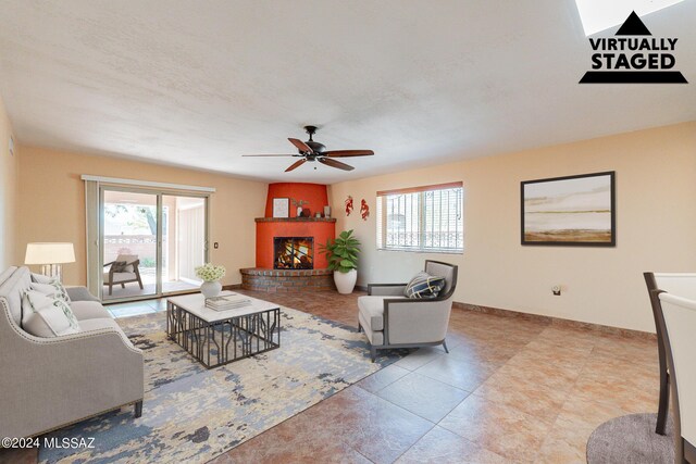 living room with baseboards, a fireplace, a ceiling fan, and a wealth of natural light