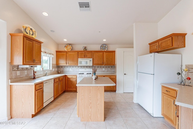 kitchen featuring white appliances, a center island, backsplash, and light tile patterned flooring