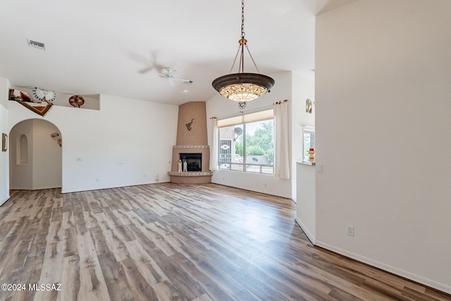 unfurnished living room featuring hardwood / wood-style floors, a large fireplace, and ceiling fan