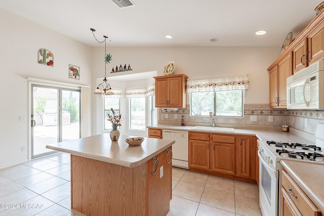 kitchen featuring decorative backsplash, white appliances, sink, a kitchen island, and hanging light fixtures