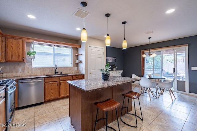 kitchen featuring an inviting chandelier, sink, hanging light fixtures, tasteful backsplash, and stainless steel appliances