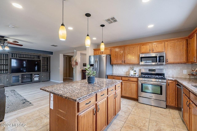 kitchen featuring a center island, stainless steel appliances, decorative light fixtures, stone countertops, and decorative backsplash