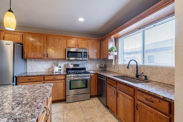 kitchen with decorative light fixtures, sink, decorative backsplash, and stainless steel appliances