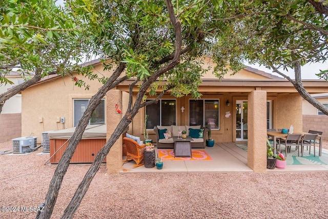 rear view of property with an outdoor living space, central AC unit, and a patio area