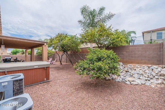 view of yard featuring cooling unit and a hot tub