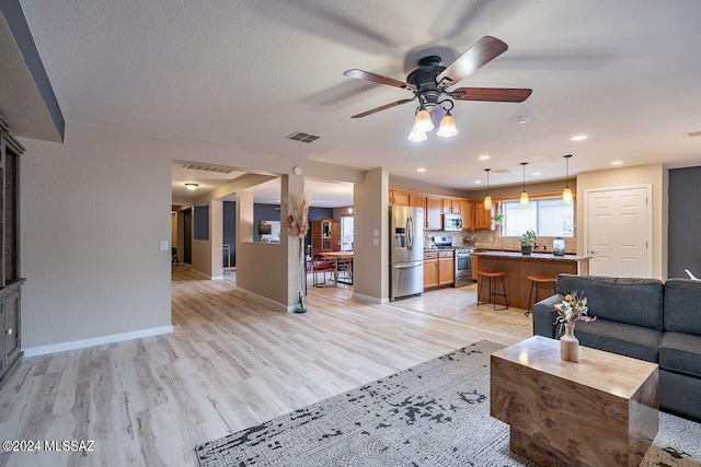 living room with ceiling fan and light hardwood / wood-style floors