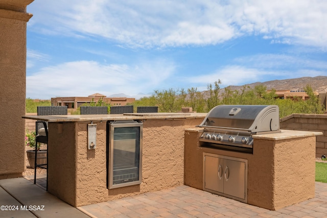 view of patio featuring wine cooler, area for grilling, and a mountain view