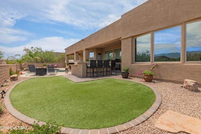 view of yard with an outdoor kitchen, a mountain view, and a patio area