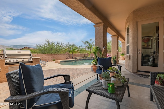 view of patio with exterior kitchen, grilling area, and a fenced in pool