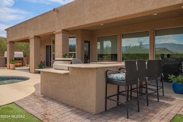 view of patio with an outdoor kitchen and a bar