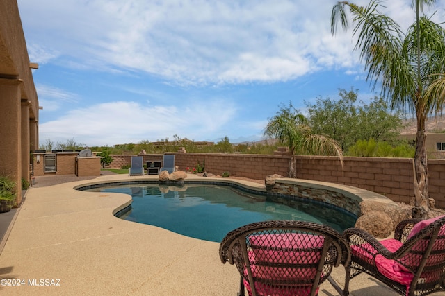 view of swimming pool with a patio and a hot tub