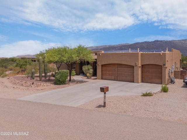 adobe home with a mountain view and a garage