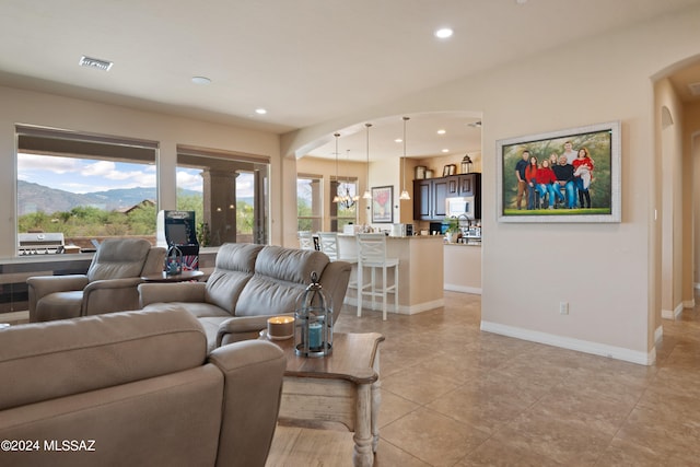 tiled living room with a mountain view and a healthy amount of sunlight