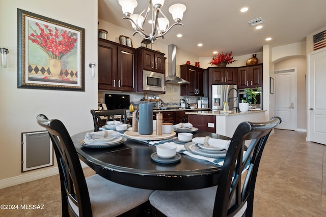 dining room featuring an inviting chandelier, sink, and light tile patterned floors