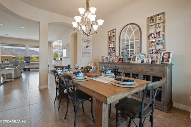 tiled dining room featuring a chandelier