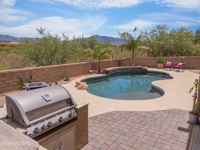 view of pool featuring a patio, a mountain view, and area for grilling