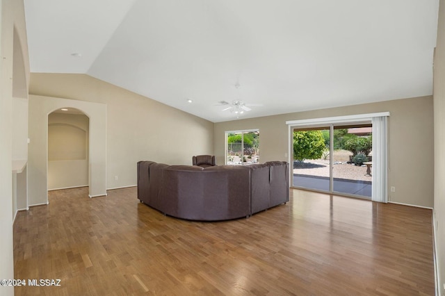 unfurnished living room with light hardwood / wood-style floors, vaulted ceiling, and ceiling fan