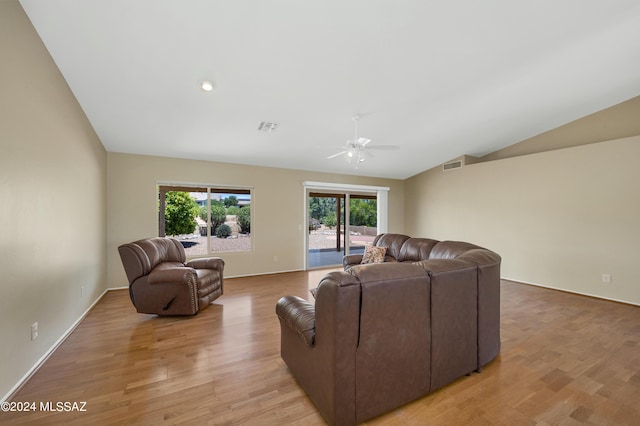 living room featuring light hardwood / wood-style floors, vaulted ceiling, and ceiling fan