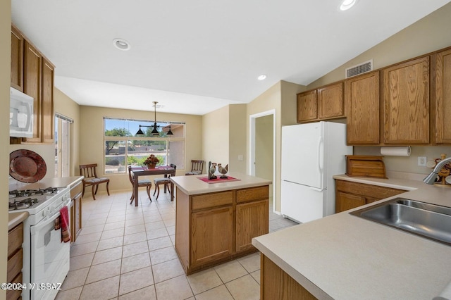 kitchen with pendant lighting, white appliances, sink, vaulted ceiling, and a kitchen island