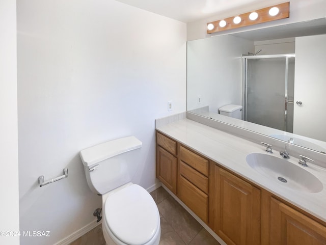 bathroom featuring tile patterned floors, vanity, toilet, and walk in shower