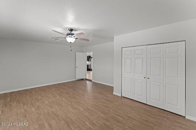 unfurnished bedroom featuring light wood-type flooring, a closet, and ceiling fan