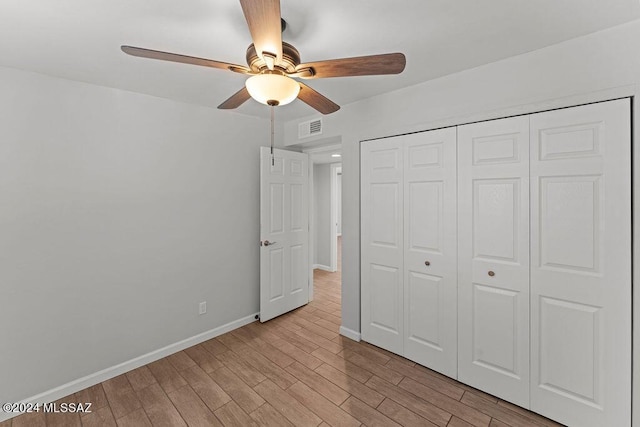 unfurnished bedroom featuring ceiling fan, a closet, and light hardwood / wood-style flooring