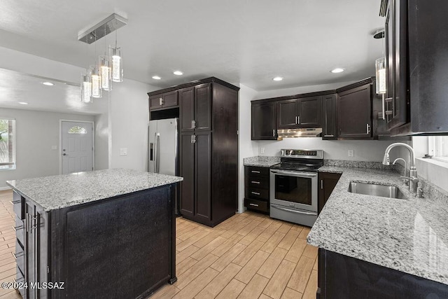 kitchen featuring sink, hanging light fixtures, light stone counters, a kitchen island, and appliances with stainless steel finishes