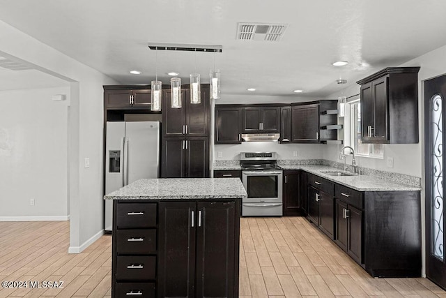 kitchen with pendant lighting, sink, light stone countertops, appliances with stainless steel finishes, and a kitchen island