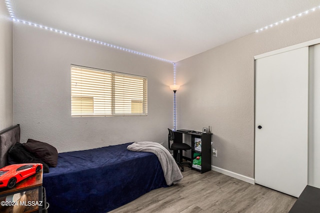 bedroom featuring light wood-type flooring and a closet