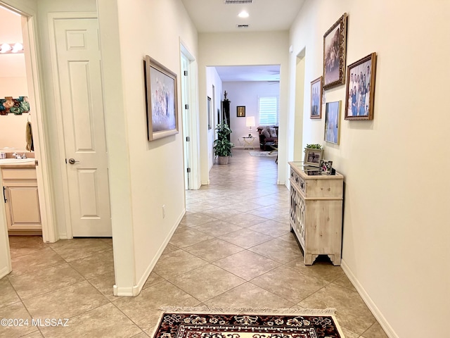 hallway featuring light tile patterned floors and sink