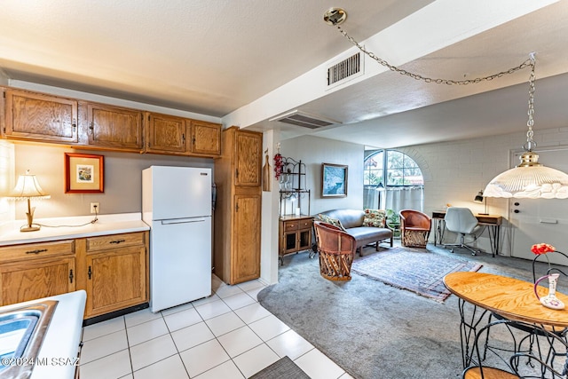 kitchen featuring white fridge, pendant lighting, and light tile patterned floors