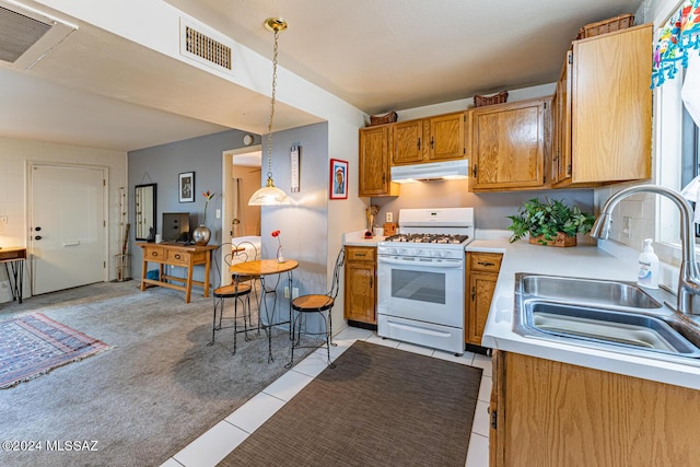 kitchen with hanging light fixtures, light tile patterned flooring, sink, and white range with gas cooktop