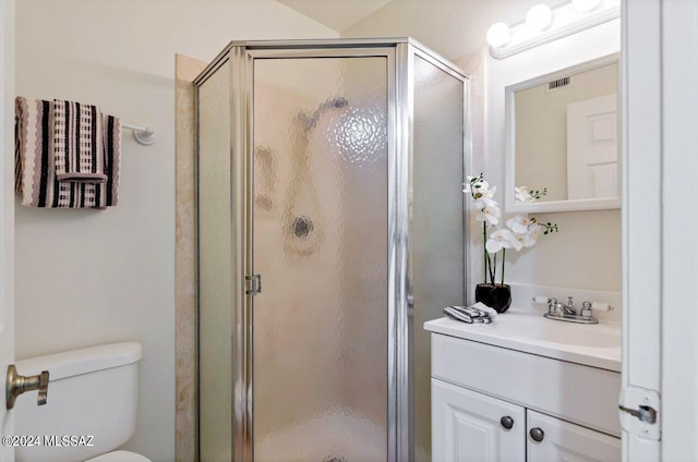 bathroom featuring vanity, an enclosed shower, and toilet