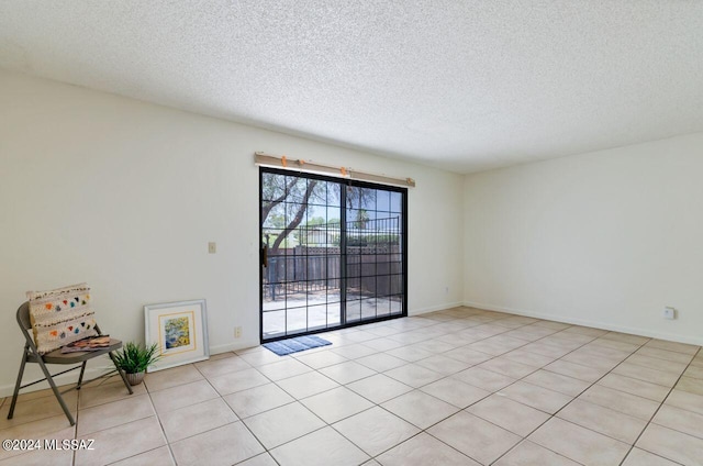 tiled spare room featuring a textured ceiling