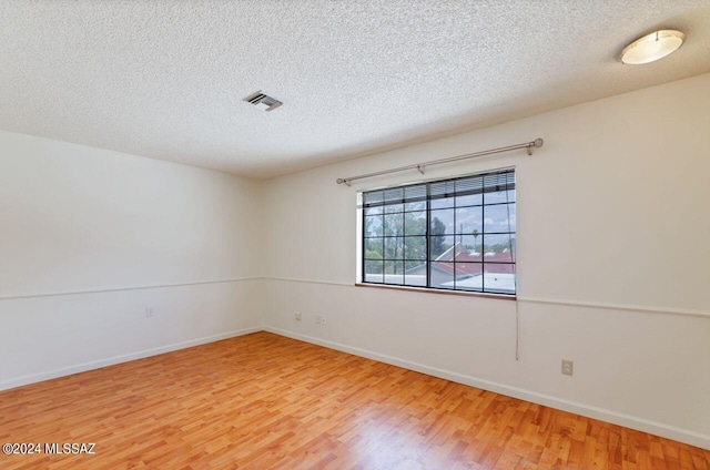 spare room with wood-type flooring and a textured ceiling