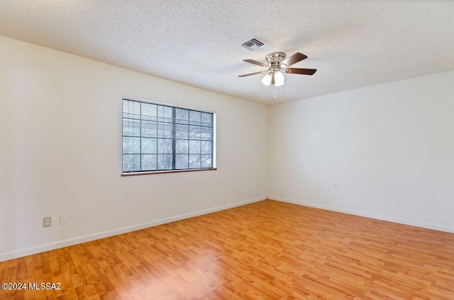 unfurnished room with ceiling fan, light wood-type flooring, and a textured ceiling