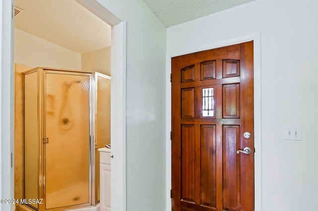 foyer entrance featuring a textured ceiling and vaulted ceiling