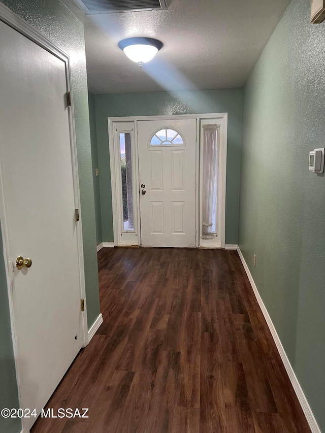 foyer with dark wood-type flooring and a textured ceiling